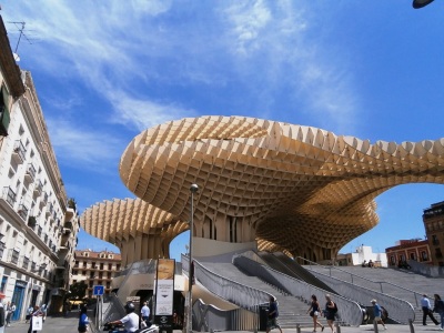 The Metropol Parasol is believed to be the largest wooden structure in the world - 490' x 230' and 85' high.  On the street level is the public market.
